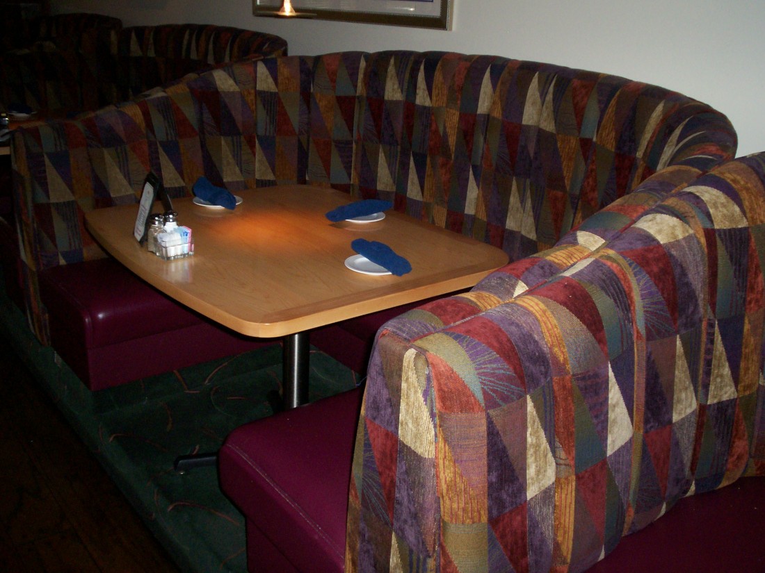 Wood Table With Booth Surrounding In Restaurant by Ferrante Manufacturing Co. in Detroit, MI